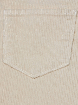 A close-up of the Scottie Corduroy Wide-Leg Pant by L'AGENCE shows beige stretch corduroy with a stitched pocket, vertical ridges, and white stitching along the edges.