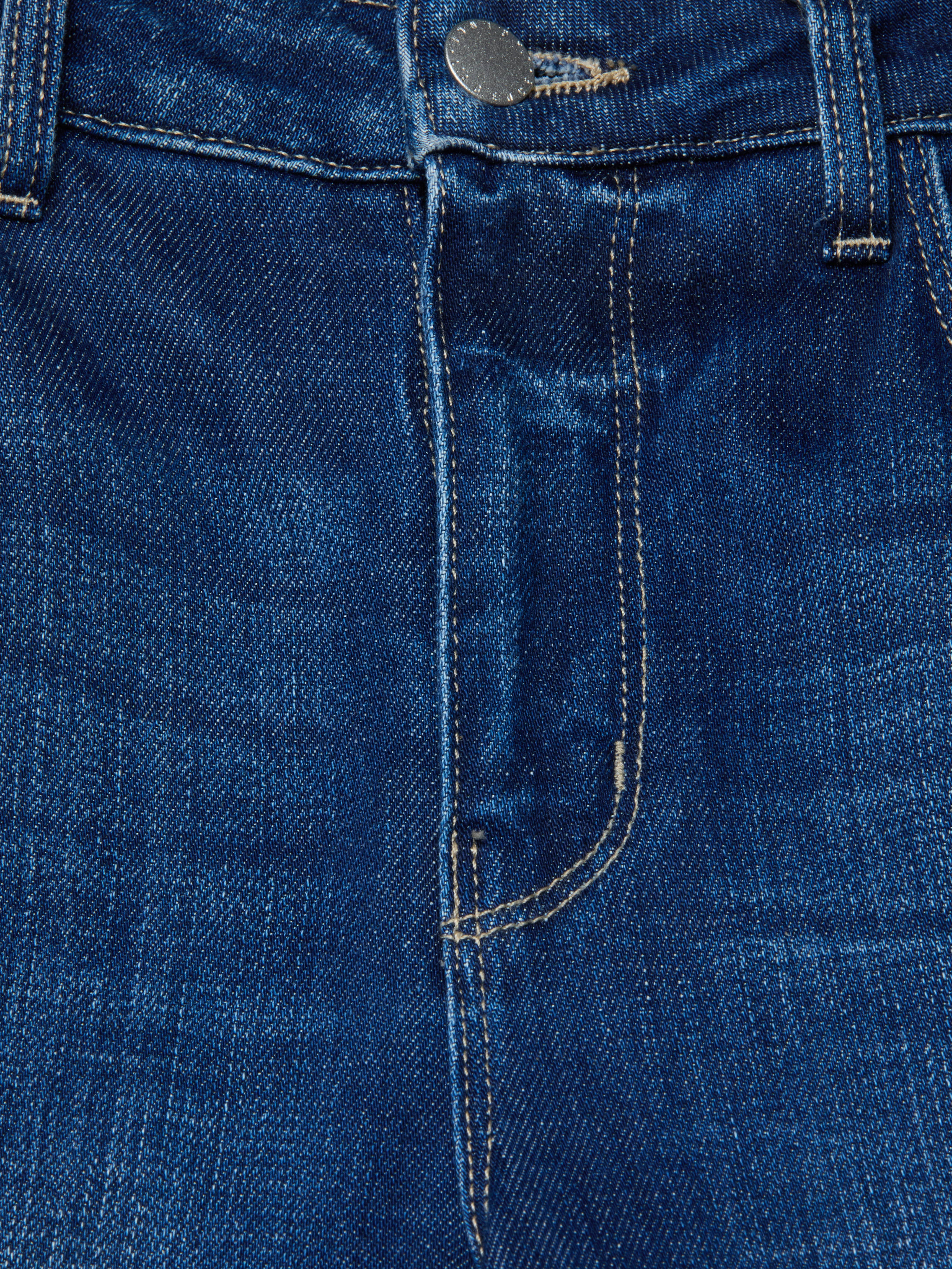 Close-up of the front of the Scottie Wide-Leg Jean in blue stretch denim, highlighting the contoured waistband, button, belt loops, zipper area, and part of the front pocket with visible stitching.