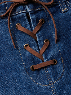 The Charis Lace-Up Jean by L'AGENCE features blue stretch denim with brown suede laces threaded through metal eyelets in a crisscross, corset-style lace-up closure, with tied ends at the top.