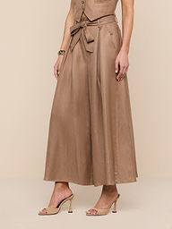A woman wears the Lowen Linen-Blend Pant—a wide-legged, high-waisted brown pant with a tie belt—paired with a matching sleeveless top and nude heeled sandals, standing against a plain white background.