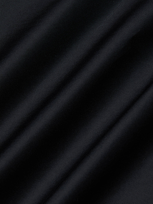 Close-up of smooth, black fabric with soft folds and diagonal shadows, evoking the silky, elegant texture of the L'AGENCE Lowen Pant.