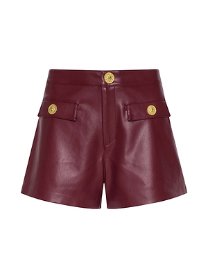 The Dionne Vegan Leather Short comes in black cherry, features front flap pockets with gold buttons, a high-rise fitted waist, and a central gold button closure.