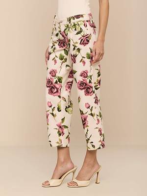 A person wearing the Blaine Cropped Stovepipe Jean with a cream rose print, paired with a white top and beige high-heeled sandals, stands against a neutral background.