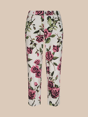 The Blaine Cropped Stovepipe Jean features a straight-leg cut, all-over pink rose and green leaf print, front pockets, and button closure, shown on a plain beige background.