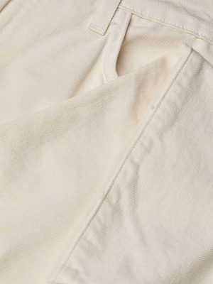 Close-up of the Blaine Cropped Stovepipe Jean in off-white, showing the front pocket, belt loop, and textured fabric. A faint stain is visible near the pocket edge.