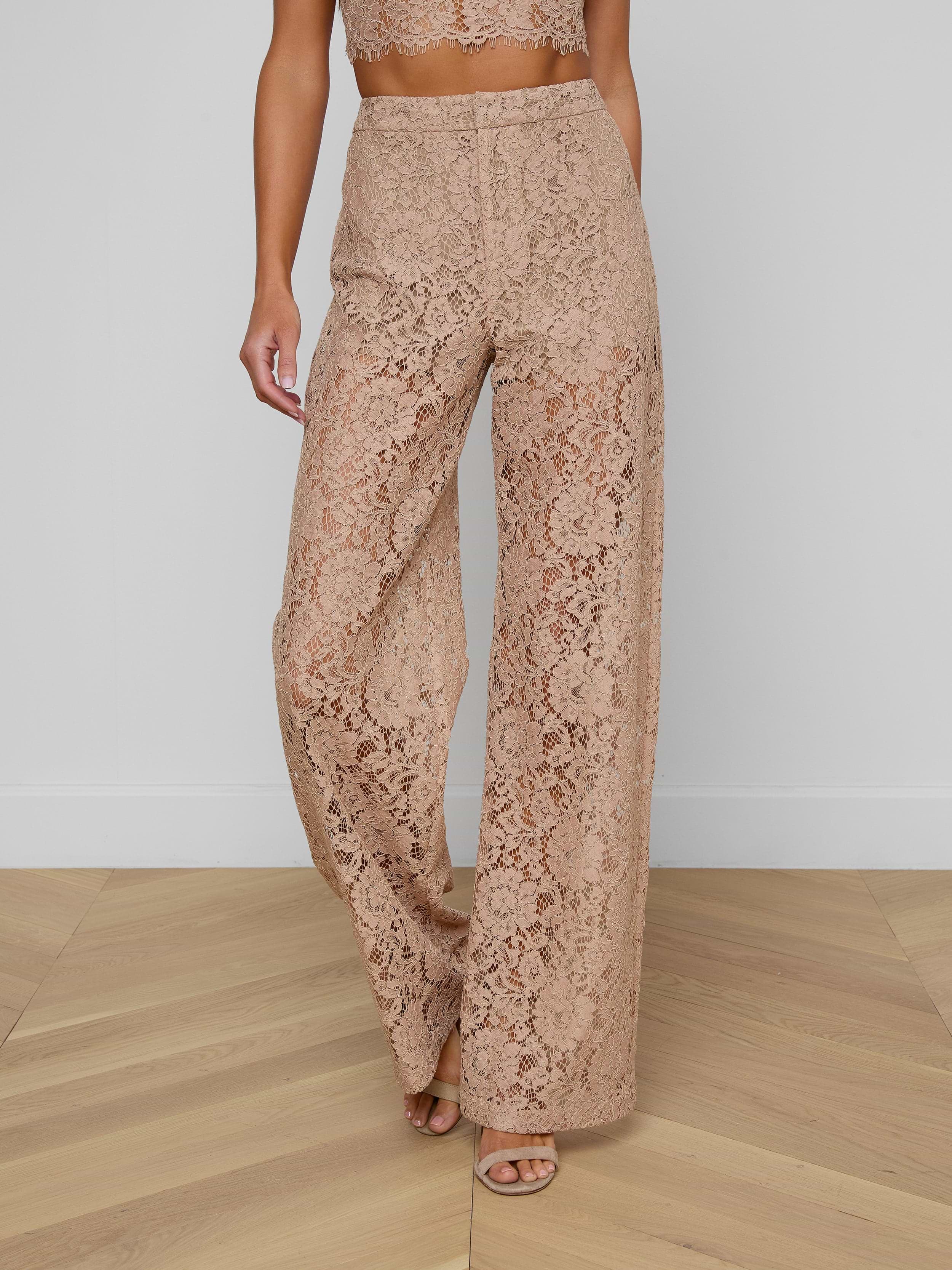 Model showcases the Livvy Lace Trouser, featuring a high-waisted, wide-leg silhouette in beige floral lace. Only her lower body is visible against a plain light background.