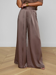 A person wearing the Aubrie Satin Pant in cardamon brown, paired with a coordinating brown top and gold bracelets on their wrist, stands against a light background.
