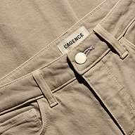 Close-up of the waistband of the tan, low-rise Joanne Low-Rise Wide-Leg Jean in stretch denim, featuring a gold button and a brand label.