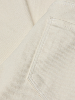 Close-up of ecru wash denim showcasing the stitched back pocket and textured seams of the Joanne Low-Rise Wide-Leg Jean.