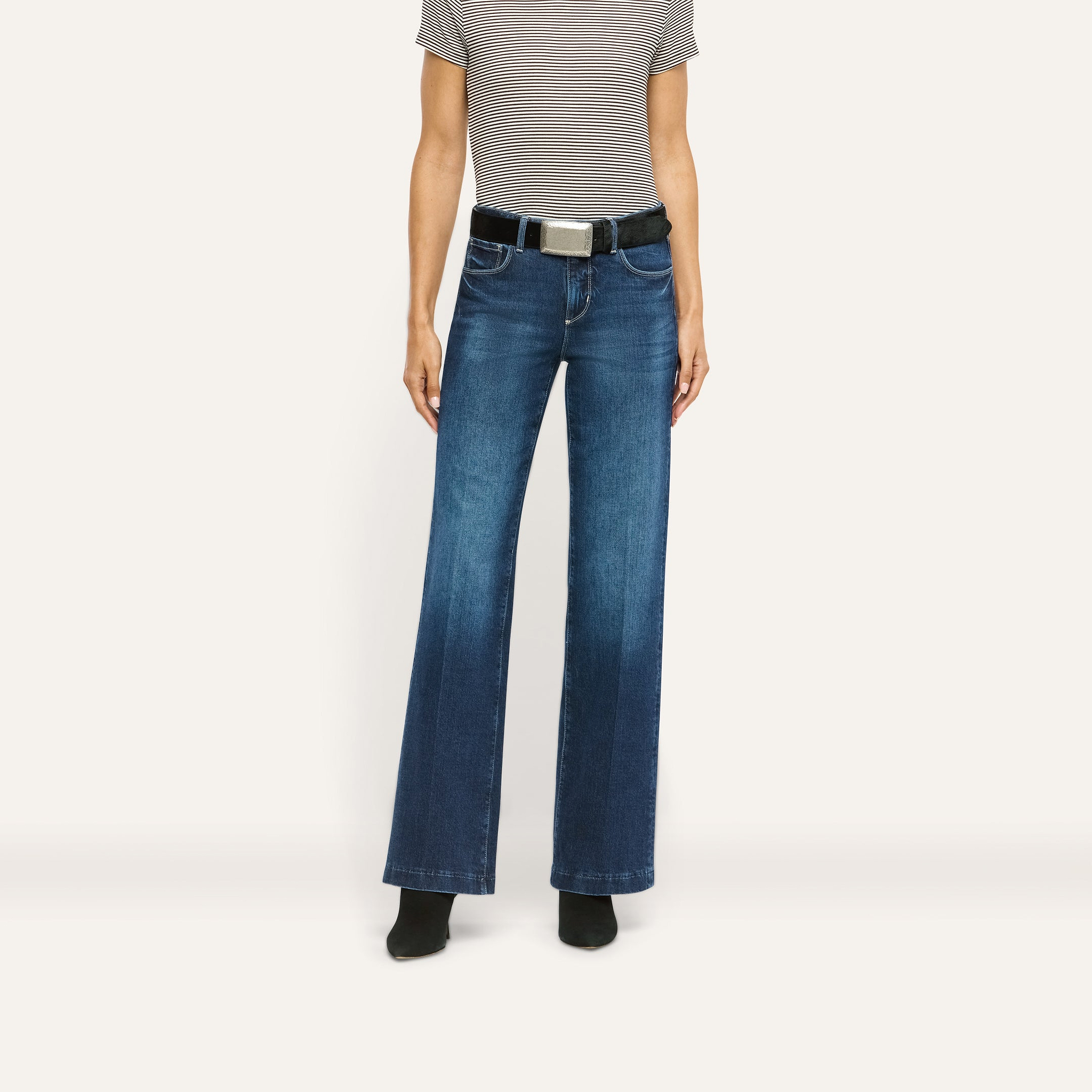 A person wearing dark blue Joanne Low-Rise Wide-Leg Jean with a black belt and a striped t-shirt.