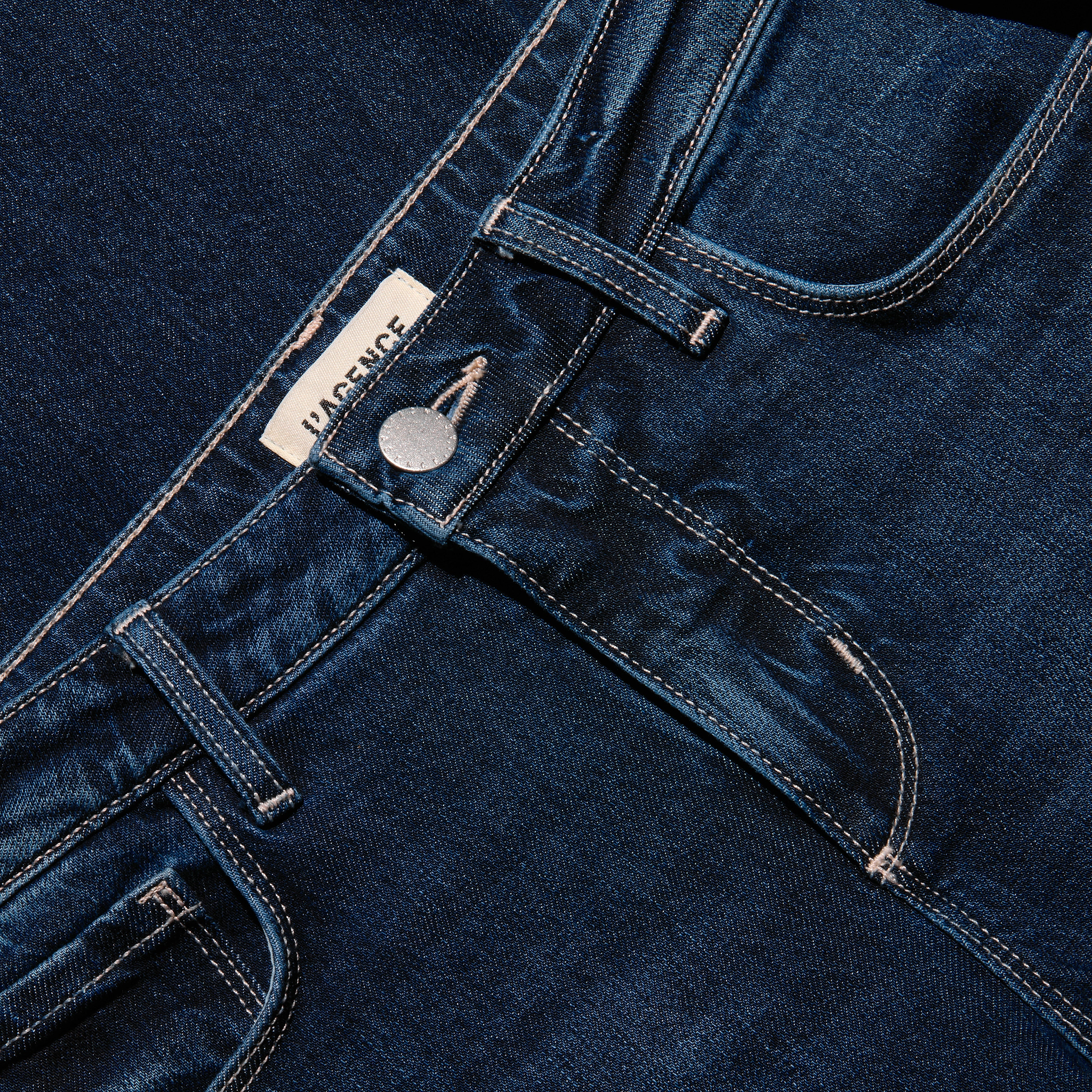 Close-up of the waistband, button, and pockets of the dark blue stretch denim Joanne Low-Rise Wide-Leg Jean.