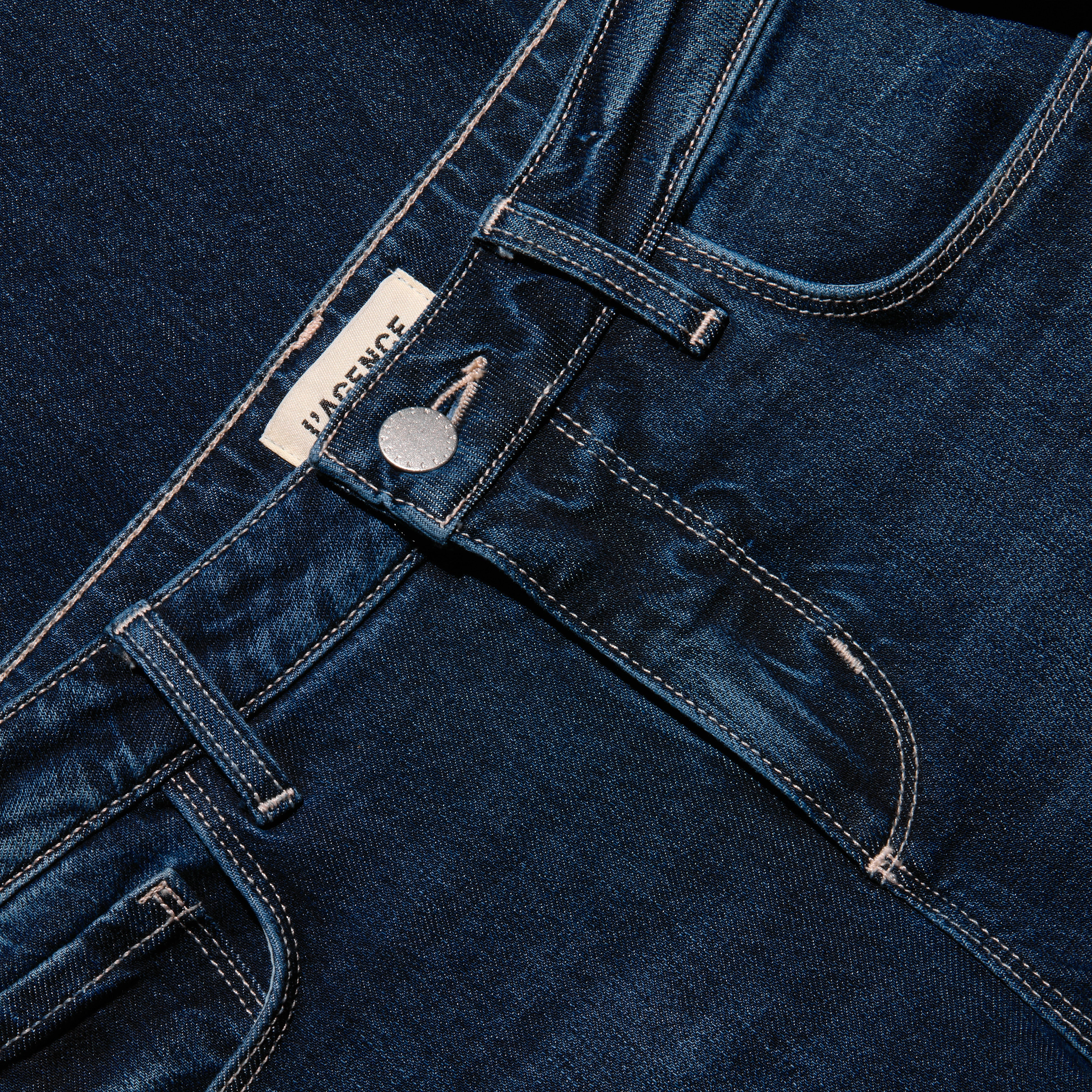 Close-up of the waistband, button, and pockets of the dark blue stretch denim Joanne Low-Rise Wide-Leg Jean.