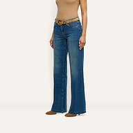Joanne Low-Rise Wide-Leg Jean in indigo wash, paired with a brown belt and brown pointed-toe heels.