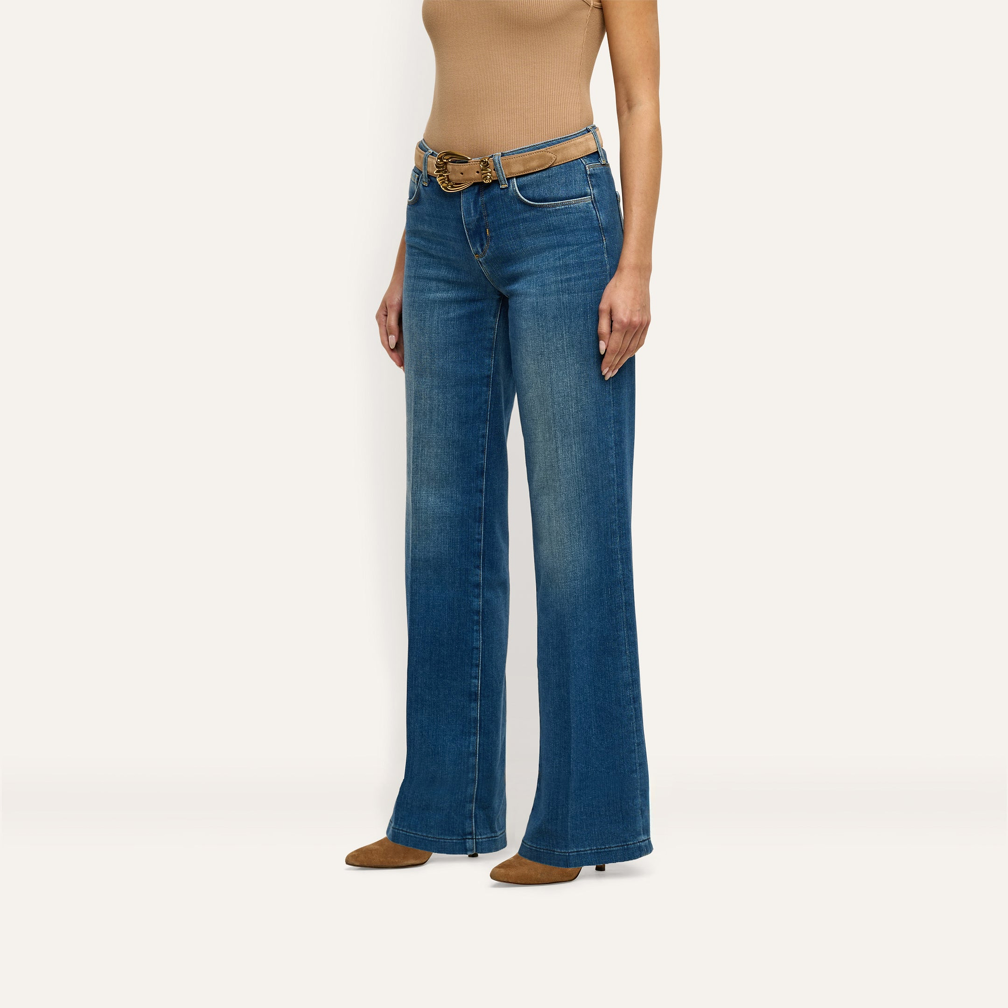 Joanne Low-Rise Wide-Leg Jean in indigo wash, paired with a brown belt and brown pointed-toe heels.