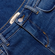 Close-up of the waistband and fly of indigo wash, low-rise Joanne Low-Rise Wide-Leg Jean, featuring a brand label near the top button.
