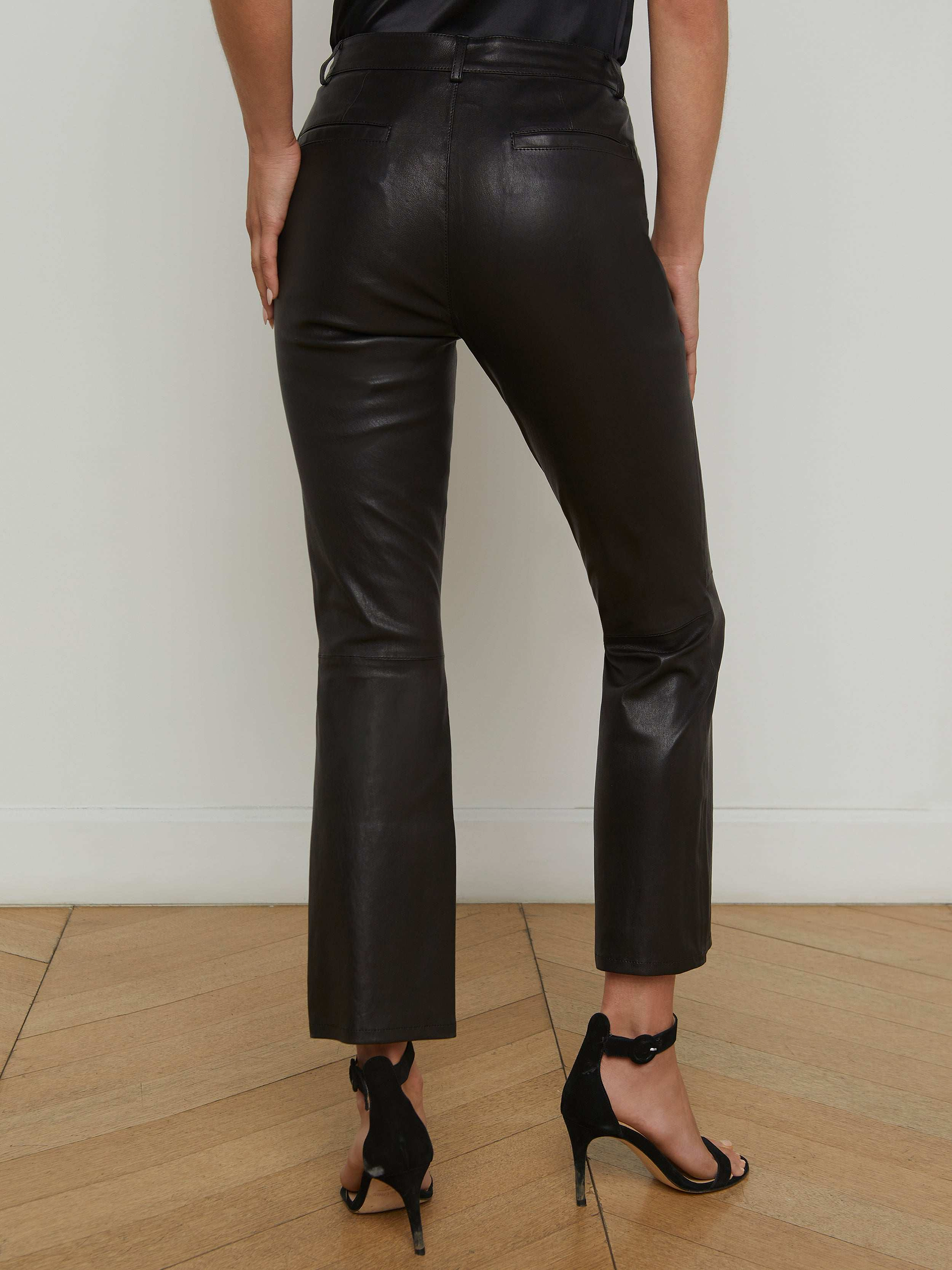 A person is shown from the back against a plain light background, wearing the Ketra Leather Bootcut Trouser and black high-heeled sandals.