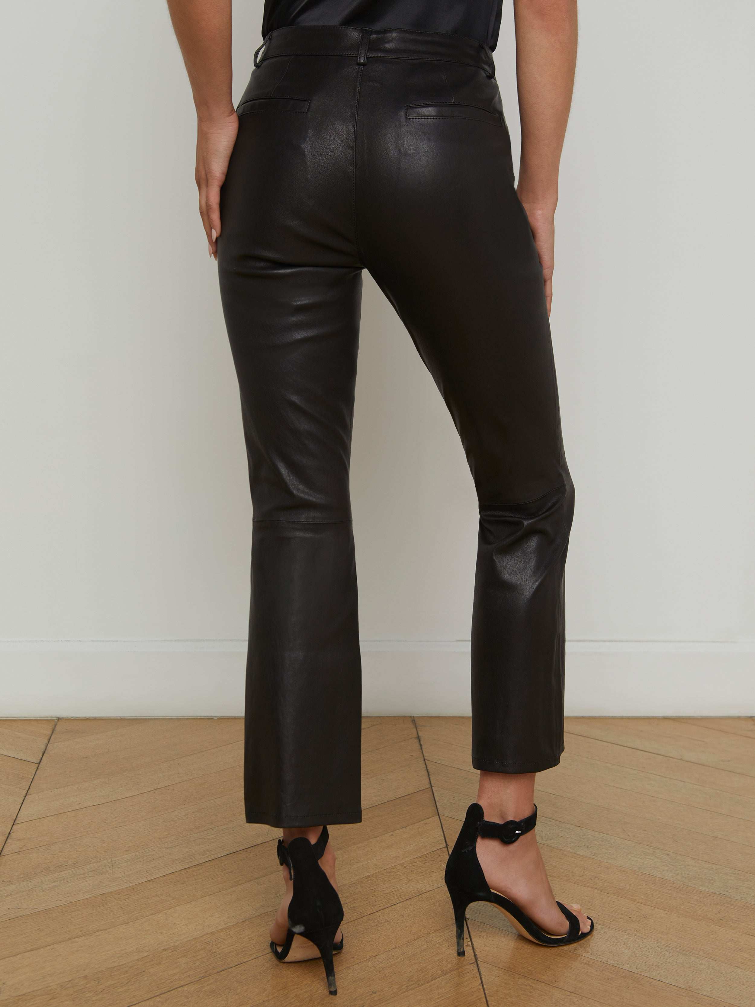 A person is shown from the back against a plain light background, wearing the Ketra Leather Bootcut Trouser and black high-heeled sandals.