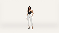 A woman wearing a black sleeveless top, white cropped pants, and black high heels stands against a plain white background.