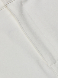 Close-up of the white stretch fabric from the Ketra Bootcut Trouser, featuring a visible seam and stitching. The texture and weave of the material are clearly shown.