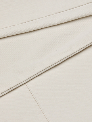 Close-up of neatly folded, cream-colored stretch cotton twill fabric with visible texture and fine diagonal lines, as featured in the Beau Wide-Leg Jean.