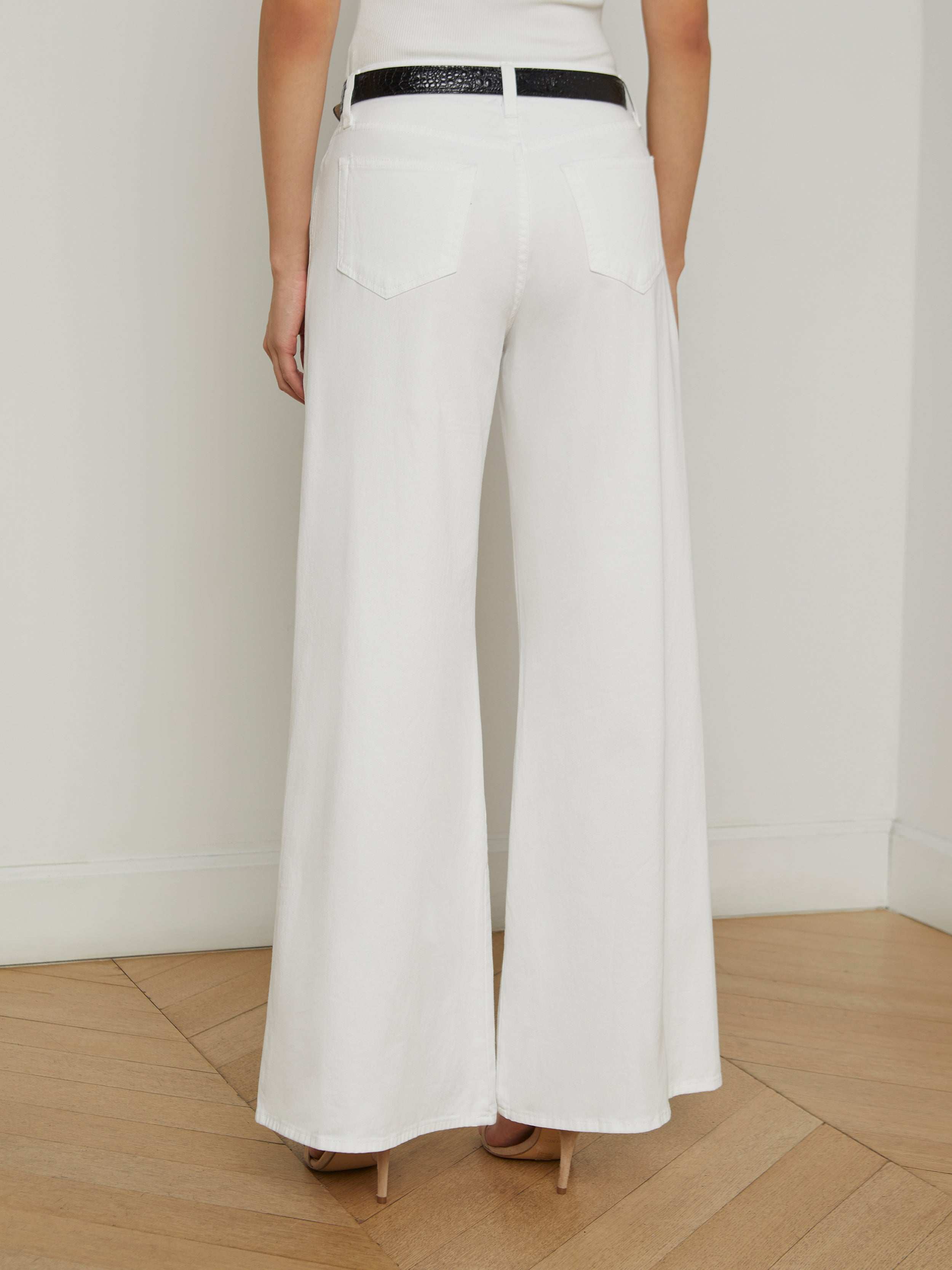 A person is shown from the back wearing the Beau Wide-Leg Jean with a black belt and tan heels against a plain background.