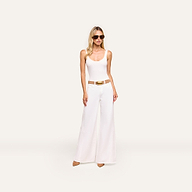 A woman in sunglasses, a white tank top, tan belt, tan heels, and Beau Wide-Leg Jean stands against a plain light background.