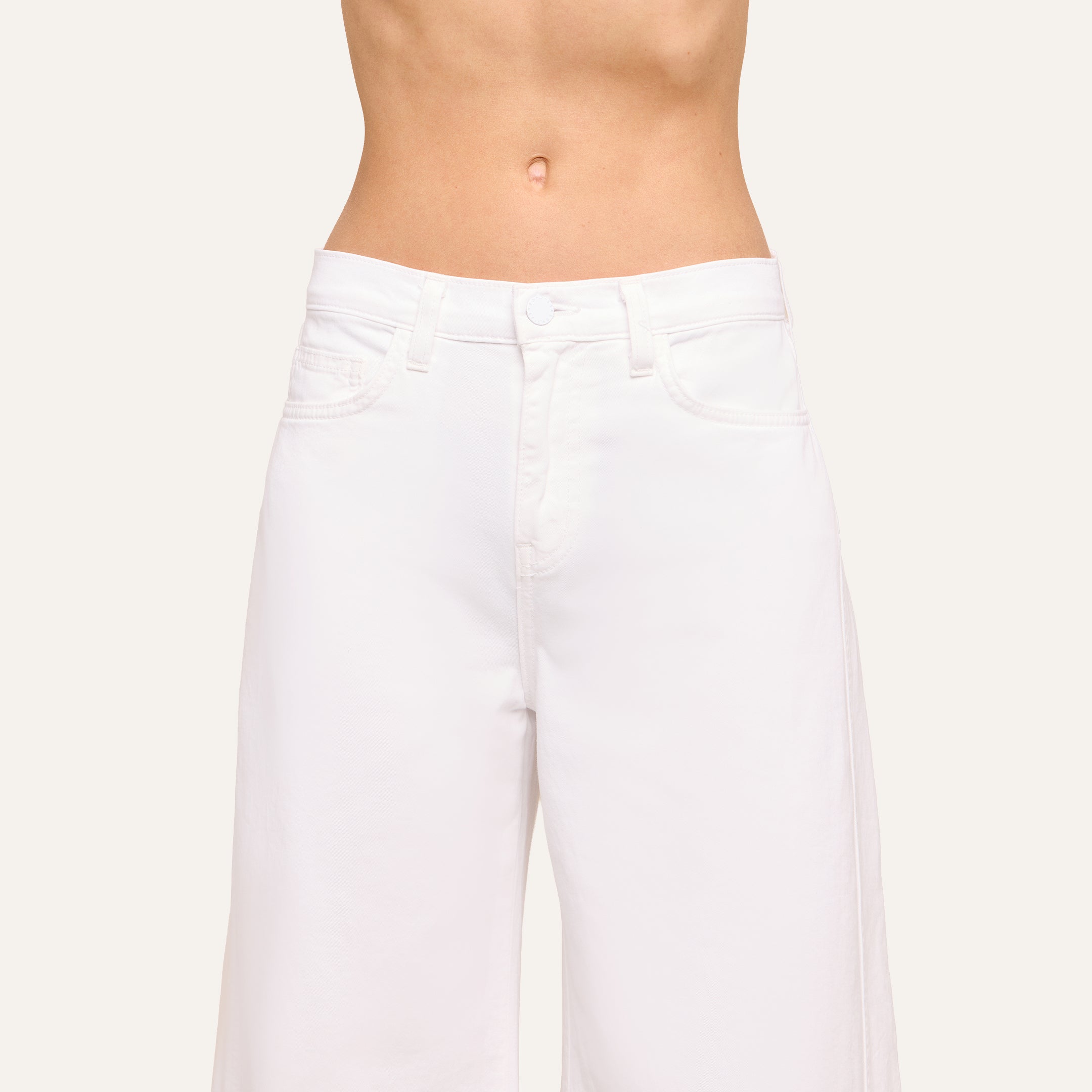 Cropped image of a person wearing the Beau Wide-Leg Jean, showcasing their midriff against a plain light background.