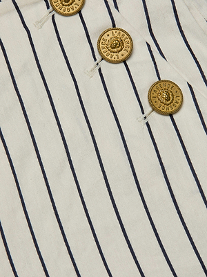 Close-up of the Kingston Striped Wide-Leg Pant by L'AGENCE Sale, featuring white fabric with thin vertical navy stripes and four gold buttons engraved with 