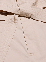 Close-up of a beige self-tie belt, part of the Damira Poplin Short, with visible stitching along the edges.