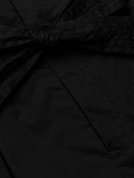Close-up of the Damira Poplin Short in black stretch poplin fabric, featuring a tied self-tie belt bow knot. The smooth and slightly shiny material suggests a polished finish, ideal for a chic look.