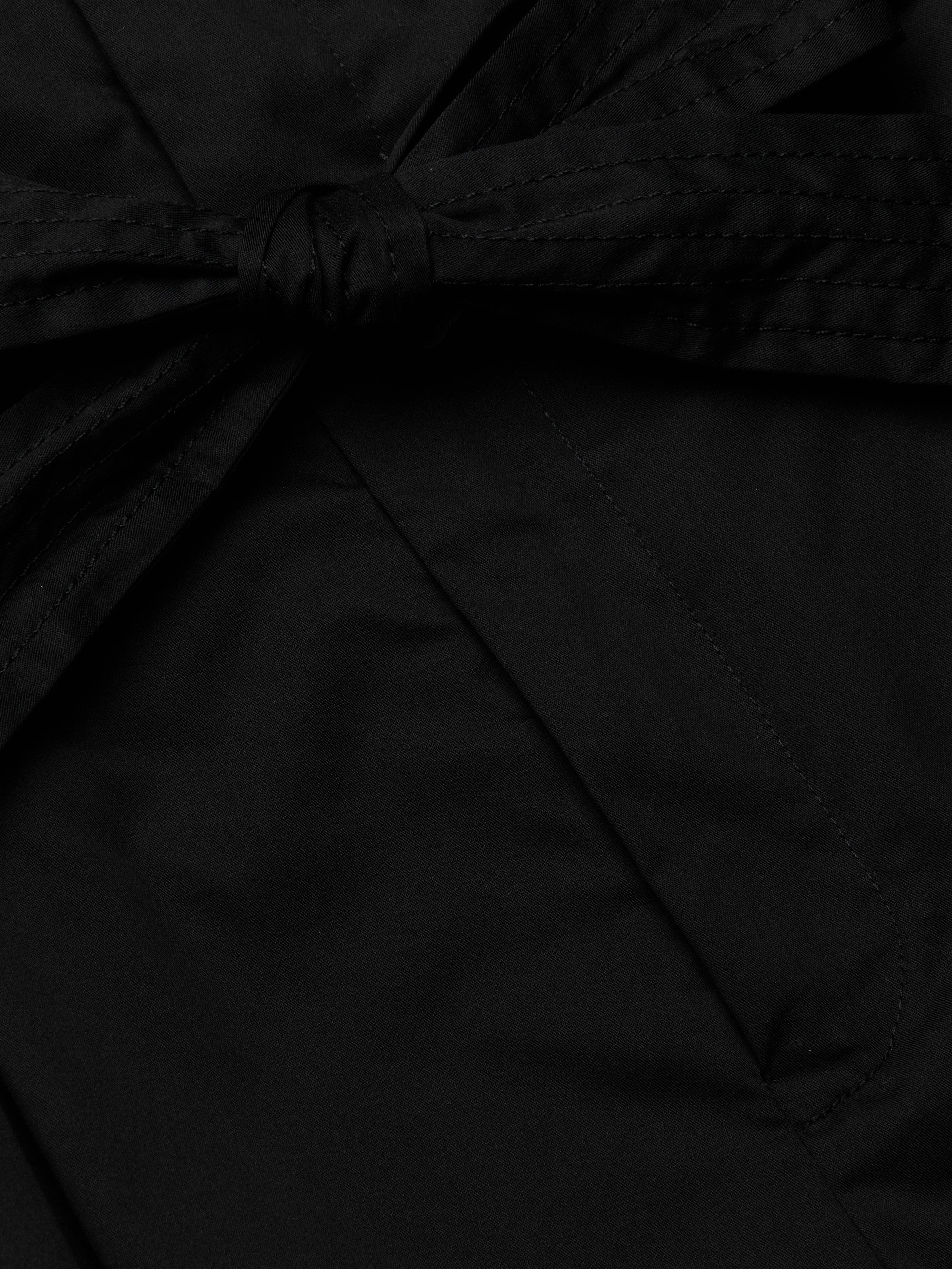 Close-up of the Damira Poplin Short in black stretch poplin fabric, featuring a tied self-tie belt bow knot. The smooth and slightly shiny material suggests a polished finish, ideal for a chic look.