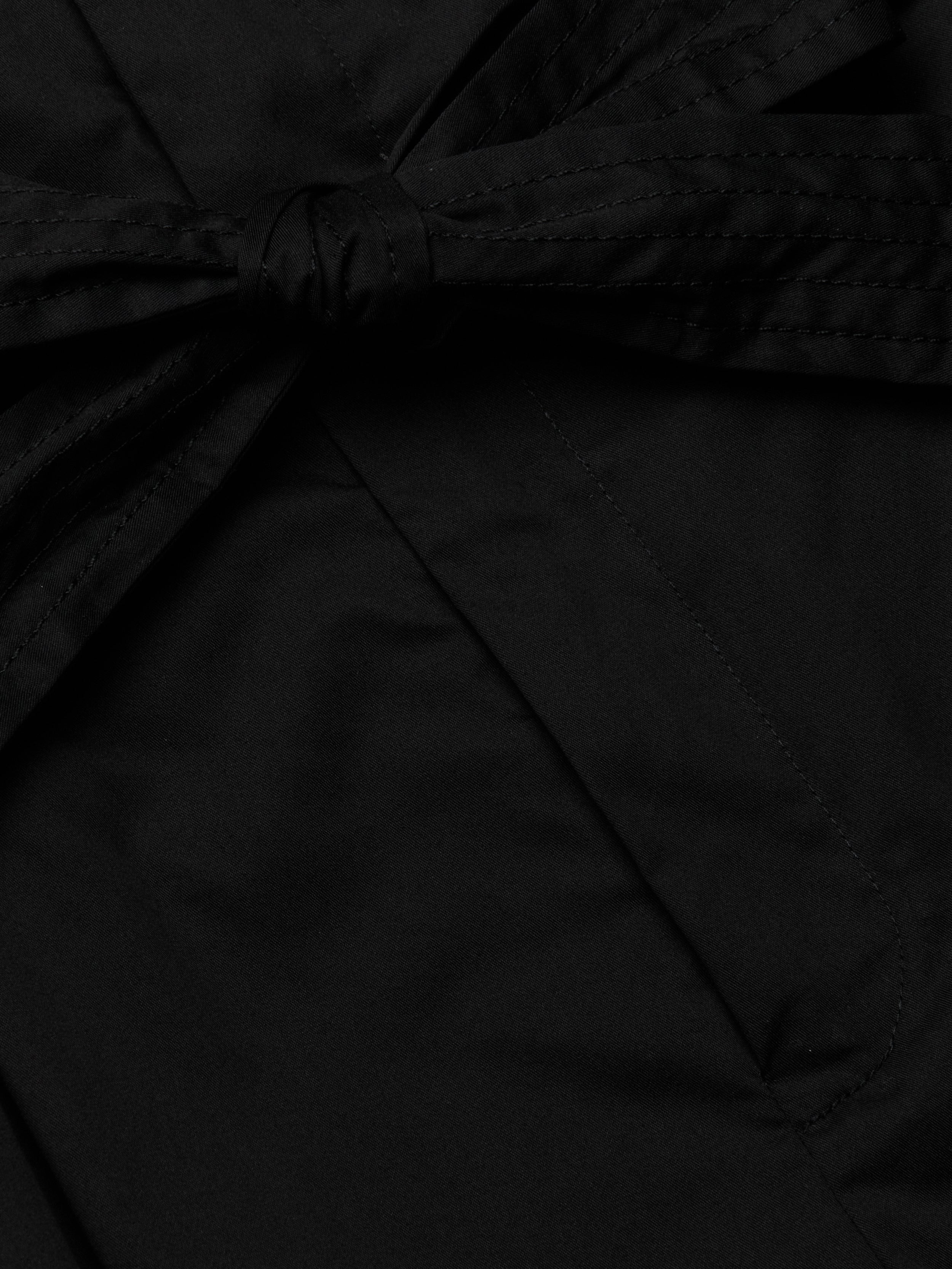 Close-up of the Damira Poplin Short in black stretch poplin fabric, featuring a tied self-tie belt bow knot. The smooth and slightly shiny material suggests a polished finish, ideal for a chic look.