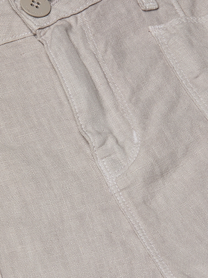 Close-up of the Cody Cropped Linen Pant fabric, highlighting a button, waistband, front pocket, and visible stitching—perfect for warm weather.