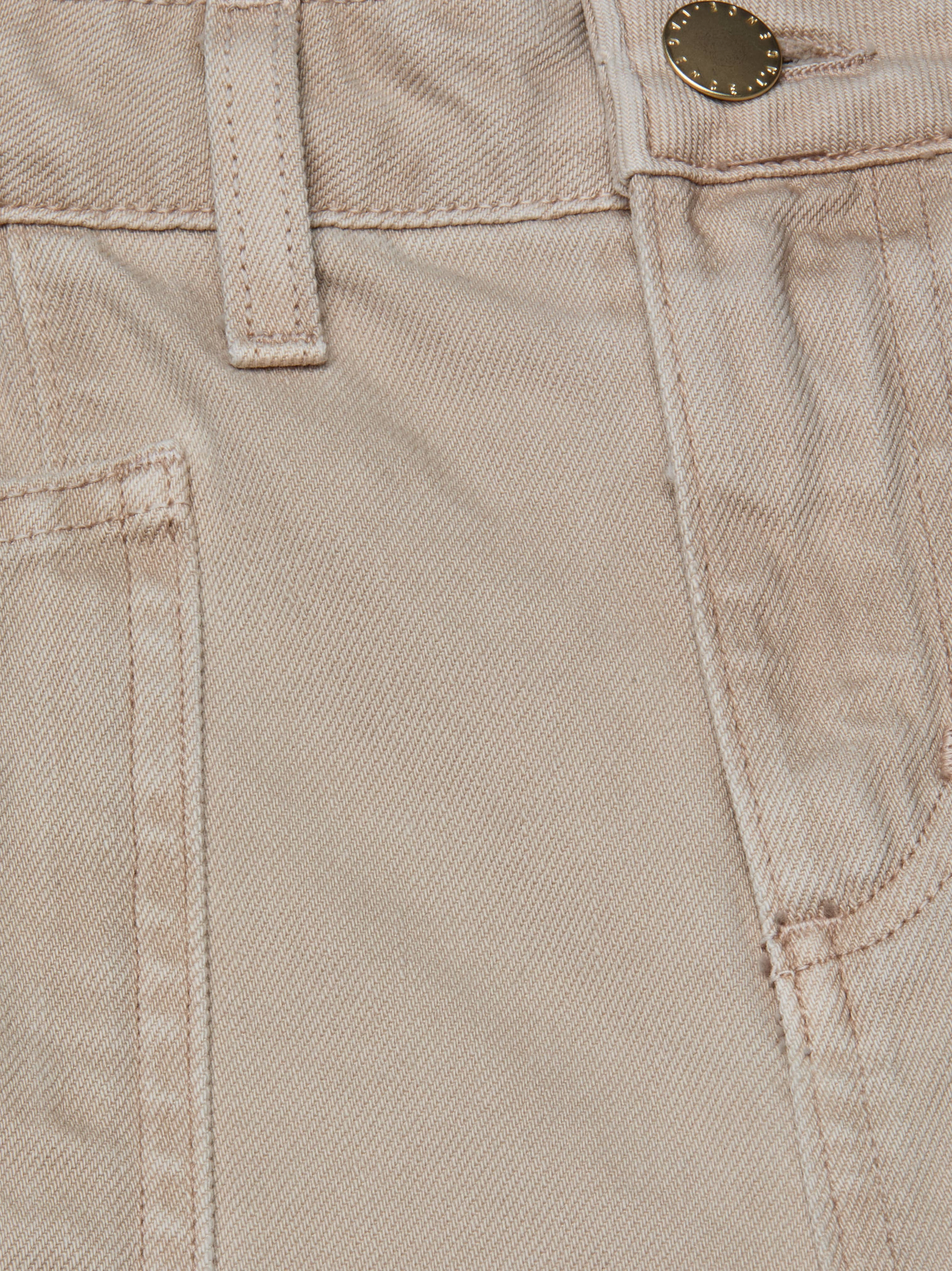 Close-up of the Cody Cropped Barrel-Leg Jean in beige, made from all-cotton denim, showing a front pocket, belt loop, waistband stitching, and a metal button.