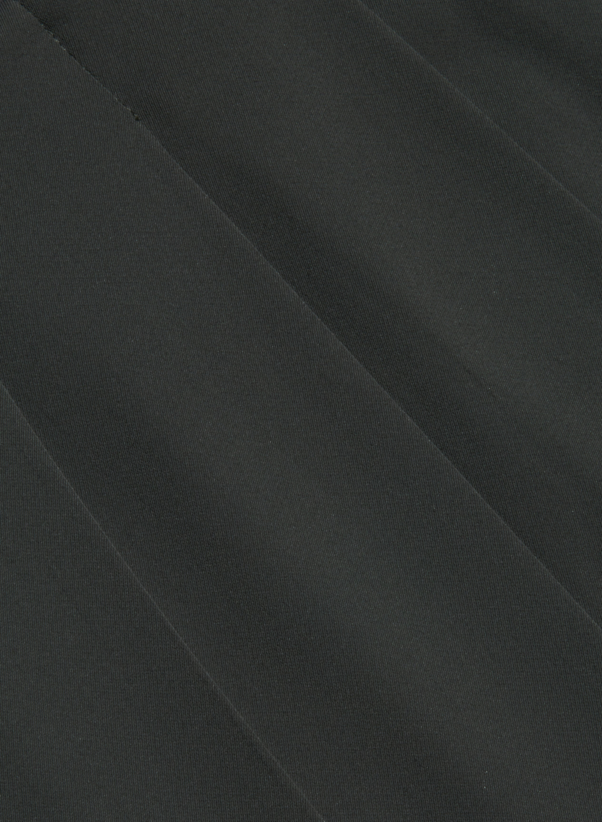 Close-up of dark gray fabric with diagonal, slightly raised lines creating a subtle striped pattern across the surface, reminiscent of the refined texture found in our Novalynn Cropped Pleated Pant.