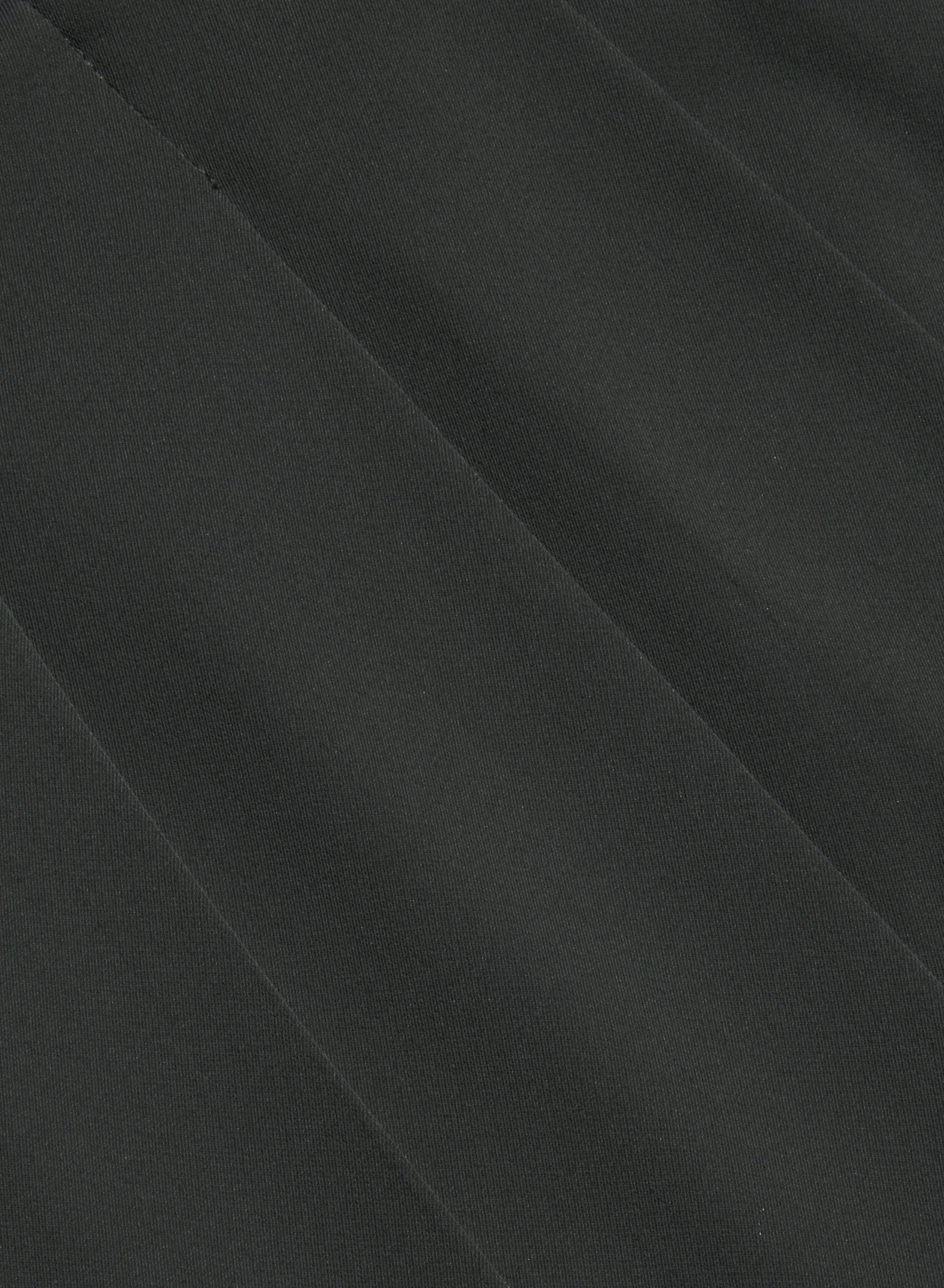 Close-up of dark gray fabric with diagonal, slightly raised lines creating a subtle striped pattern across the surface, reminiscent of the refined texture found in our Novalynn Cropped Pleated Pant.