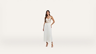 A woman in a white sleeveless dress and heels stands against a plain white background, posing with one hand on her hip.
