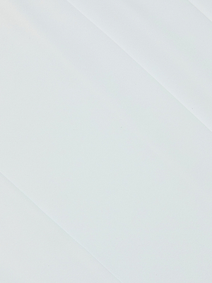 A smooth white surface with subtle diagonal lines evokes the minimal, tailored look of Novalynn Cropped Pleated Pant, inspired by its pleated design and modern cropped fit.