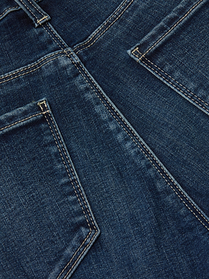 Close-up of the Cara Low-Rise Bootcut Jean in blue, featuring two back pockets, contrasting stitching, a central seam, and made from super stretch denim.