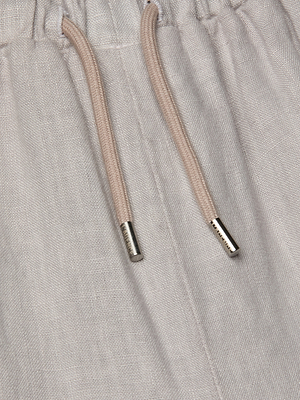 Close-up of the Mariko Linen Jogger highlighting a textured fabric and a drawstring waist with beige cords and metallic tips, loosely tied.