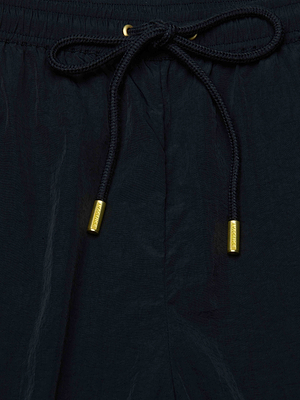 Close-up of the Mariko Jogger’s waistband, showcasing a black cord with gold metal tips tied in a bow at the center.
