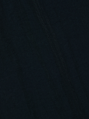 A close-up of the Mariko Jogger's dark, water-repellent nylon surface shows subtle shading and faint diagonal lines in the textured fabric.