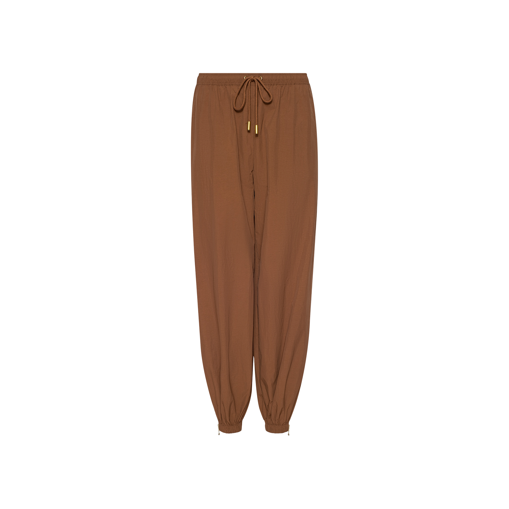 The Mariko Jogger, crafted from water-repellant nylon in brown, features a modern jogger silhouette with elastic cuffs, gold metal tips on the drawstrings, and a relaxed fit, displayed on a white background.