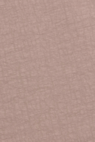 A close-up of a textured, light brown surface with a crisscross pattern resembling soft leather or paper, reminiscent of the subtle sheen and finish found in the lightweight, water-repellent nylon used for the Mariko Jogger.