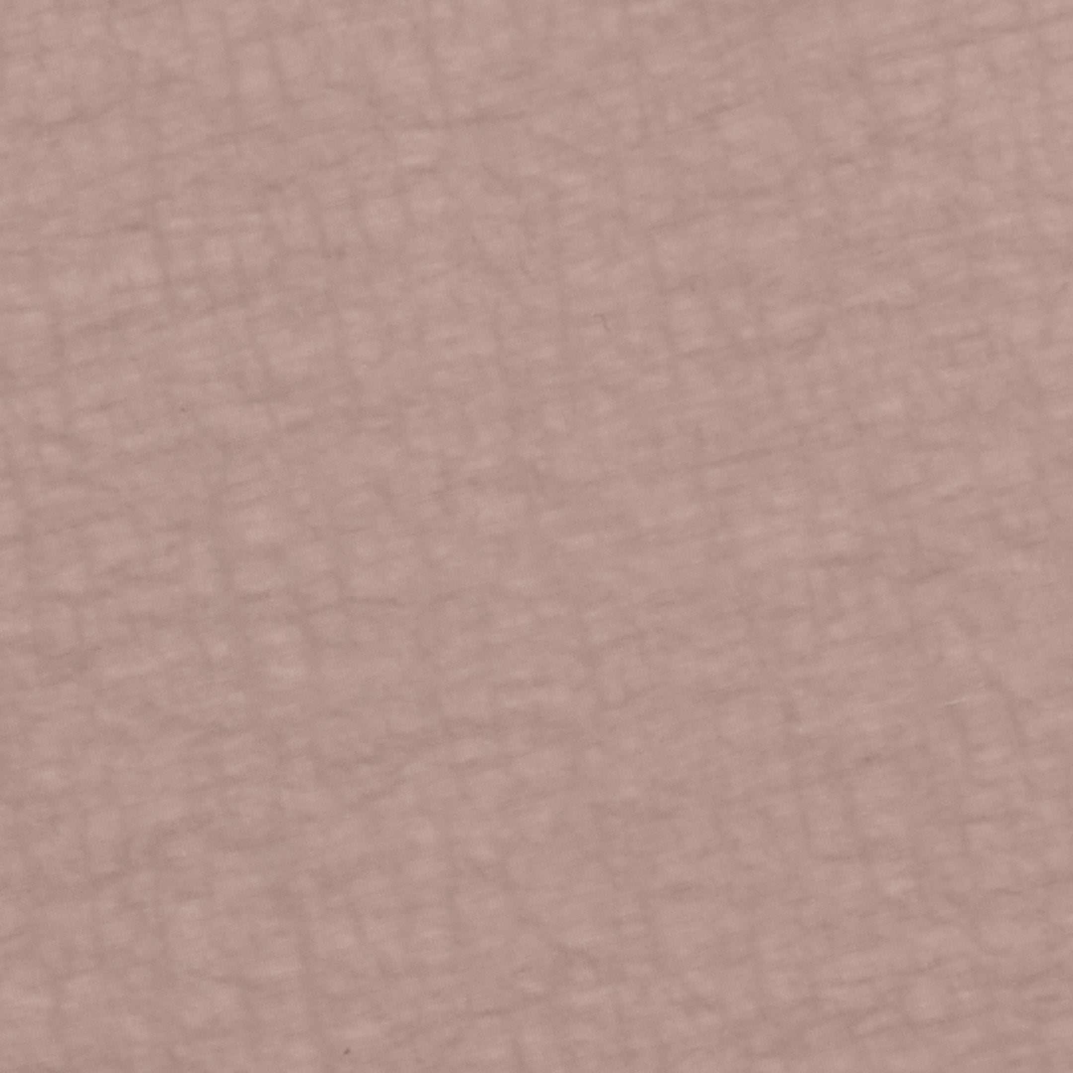 Close-up of the Mariko Jogger’s textured surface in muted pinkish-beige and light cardamom brown, featuring a subtle pattern of intersecting lines reminiscent of soft, crisscrossed fabric or water-repellent nylon.
