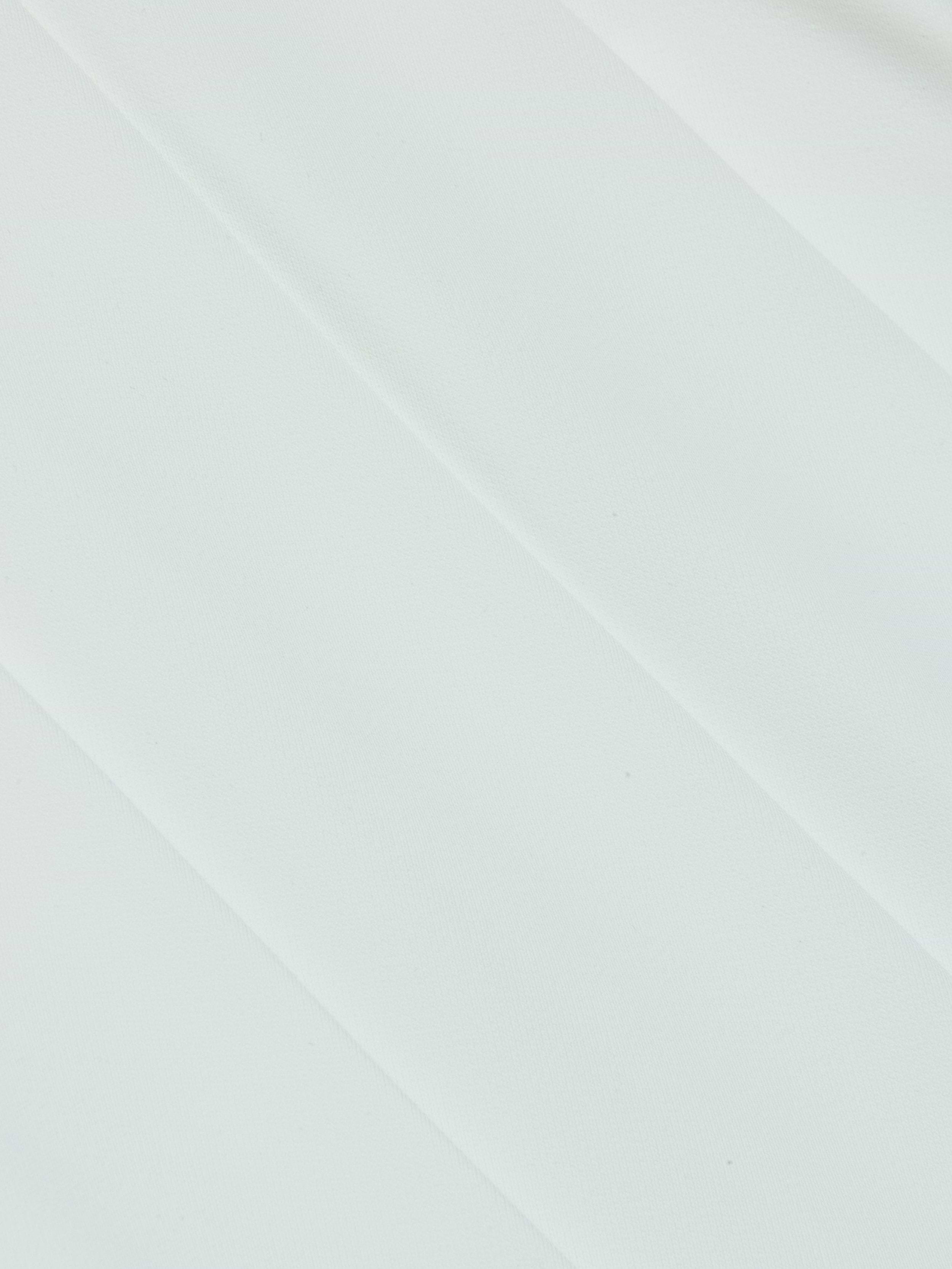 Light gray, diagonal bands run across the smooth, minimalist background of the Naamah Pleated Short, reminiscent of fluid suit fabric and resort rotation style, creating a soft, subtle striped pattern with gentle shading.