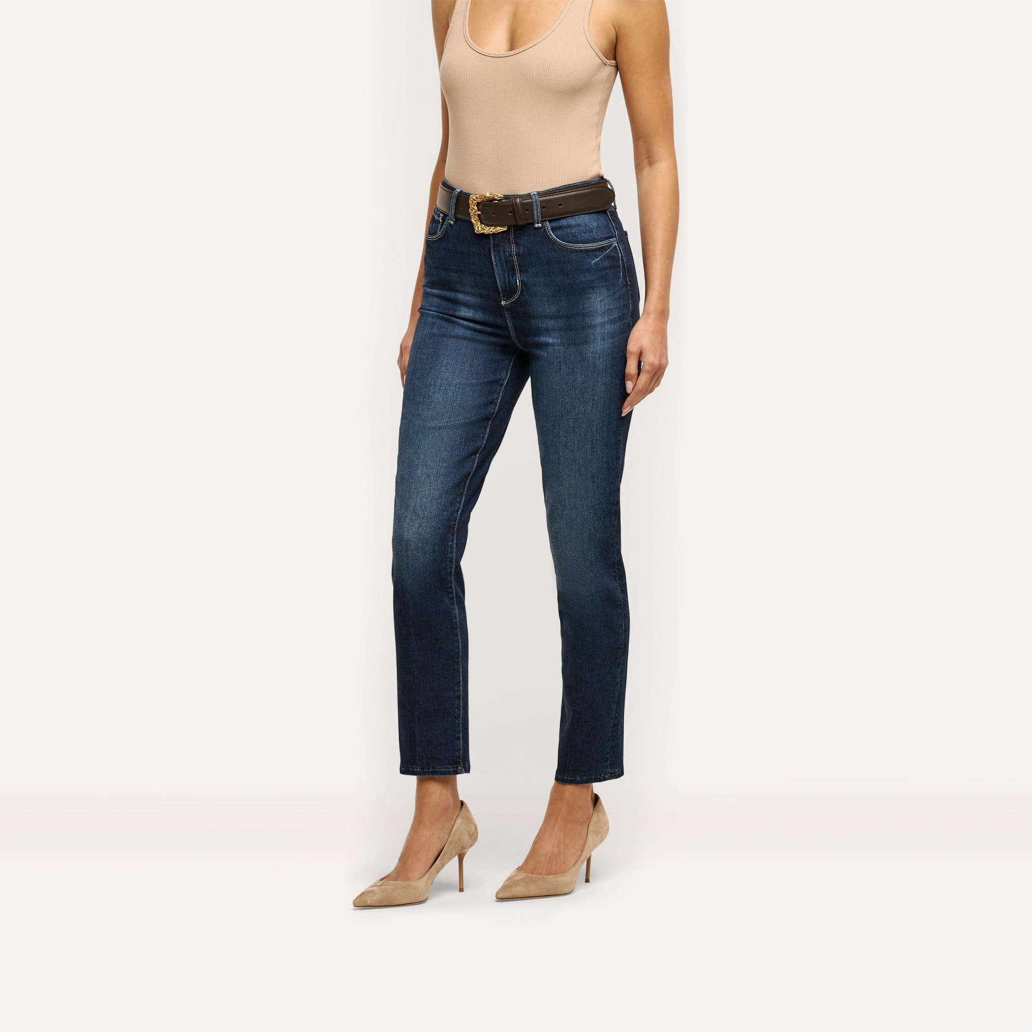 Celestia Slim-Leg Jean in dark-wash, ultra high-rise slim denim worn with a brown belt and tan pumps.