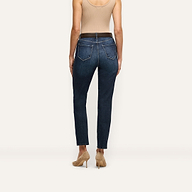 Back view of a person wearing Celestia Slim-Leg Jean ultra high rise, slim-leg stretch denim jeans, a tan tank top, a dark belt, and beige stiletto heels.