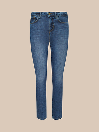 The Celestia Slim-Leg Jean features a high rise and skinny silhouette in an indigo wash, designed with a button and zip closure, front and back pockets, and crafted from stretch denim. It is displayed on a beige background.