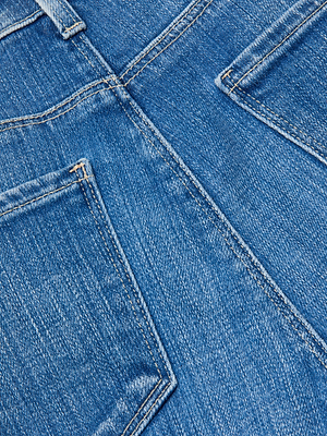 Close-up of the back pockets and seam on the L'AGENCE Celestia Slim-Leg Jean, showcasing the detailed texture and stitching of the high-rise denim fabric.